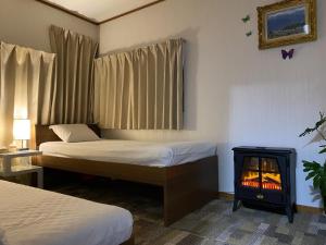 木更津市にあるRelax Inn - Vacation STAY 68048vのベッド2台と暖炉付きのホテルルームです。