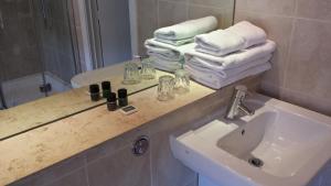 a bathroom with a sink, mirror, soap dispenser and towel rack at Remont Oxford Hotel in Oxford