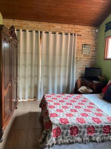 Schlafzimmer mit einem Bett mit einer roten und weißen Decke in der Unterkunft Sítio Vale da Colina-Nazaré Paulista - 6 pessoas in Nazaré Paulista + 11 Fotos