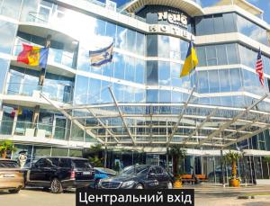 un gran edificio con coches estacionados frente a él en NEMO Hotel Resort & SPA en Odesa