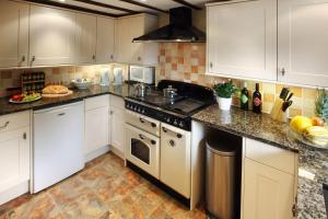 a kitchen with white cabinets and granite counter tops at The Manor House in Church Stretton