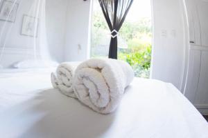 uma toalha branca sentada em cima de uma cama em Casa Grande Flats em Abraão