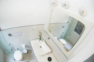 ein Badezimmer mit 2 WCs und einem großen Spiegel in der Unterkunft Casa Grande Flats in Abraão