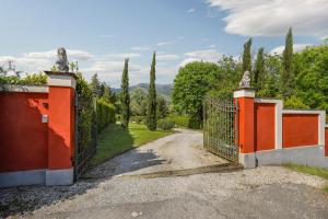 une porte orange menant à une allée avec un chemin de terre dans l'établissement HOME HILL, à Capannori