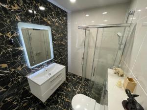 La salle de bains est pourvue d'un lavabo, d'une douche et d'un miroir. dans l'établissement 15 minutes to old town, à Vilnius