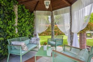 une terrasse avec un canapé bleu, des chaises et une table dans l'établissement HOME HILL, à Capannori