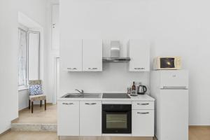 a white kitchen with a stove and a microwave at SORRENTO BEAUTY in Sorrento +18 photos