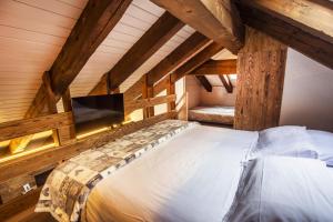 a bedroom with a bed with a tv on the wall at Hotel Pilier D'Angle & Wellness in Courmayeur