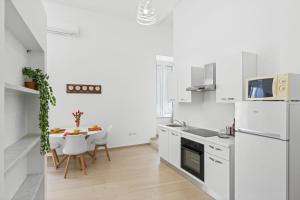 a kitchen with white appliances and a table with chairs at SORRENTO BEAUTY in Sorrento