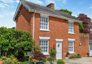 een oud rood bakstenen huis met witte ramen bij City to Country Retreat Luxury Cottage with Hot Tub in Toppesfield