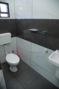 a bathroom with a white toilet and a sink at Thekkumpuram Tourist Home in Malappuram