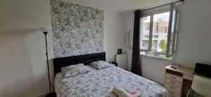 niewielka sypialnia z łóżkiem i oknem w obiekcie Appartement confort Clichy JO 2024 w mieście Clichy