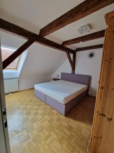 um quarto com uma cama num sótão com vigas de madeira em Casa di Giovanni - Österreich em Frohnleiten