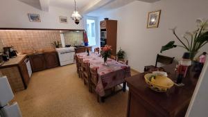 a kitchen with a dining table and a kitchen with a tableablish at La Maison de Gaëtan in LʼIsle-en-Dodon