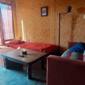 Zimmer mit 2 Betten, einem Tisch und einem Sofa in der Unterkunft Posada Mar Azul con Jacuzzi in Punta Del Diablo