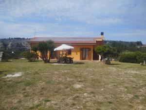 a house with a table and chairs in a yard at Grotta Delle Fate in Ossi