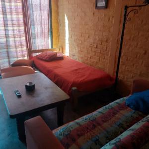 a bedroom with a bed and a table and chairs at Posada Mar Azul con Jacuzzi in Punta Del Diablo