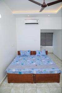 a bed with a blue comforter in a bedroom at Thekkumpuram Tourist Home in Malappuram