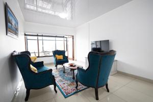a living room with blue chairs and a table at Safi Elegant Self-catering Suite 5 in East London