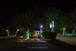 a building with a green light at night at Wild natural safari bunglow in Udawalawe