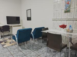 a room with a table and chairs and a tv at Apartamento aconchegante em Cacoal4 in Cacoal