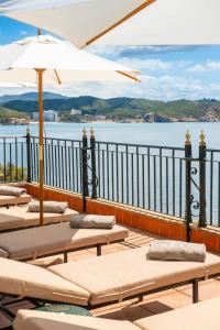 eine Reihe von Liegen auf einem Balkon mit Wasser in der Unterkunft Hotel Cala Fornells in Paguera