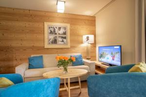 a living room with a couch and a tv at SWISSPEAK Resorts Meiringen in Meiringen