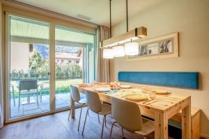 a dining room with a table and chairs and a large window at SWISSPEAK Resorts Meiringen in Meiringen