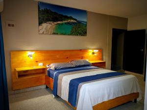 una camera da letto con un letto e un dipinto sul muro di Villa Cabana Inn a Playa Dormida