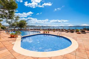 a pool at a resort with the ocean in the background at Hotel Cala Fornells in Paguera +37 photos
