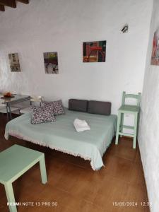 a bed in a room with a table and a chair at MALUAN in Conil de la Frontera
