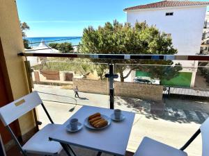 une table avec un plateau de beignets sur un balcon dans l'établissement Apartamanto Frente a la Playa, Torre de Benagalbon, à Torre de Benagalbón