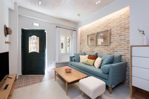 ein Wohnzimmer mit einem blauen Sofa und einer Ziegelwand in der Unterkunft La Signora Cofineta by Anita Holiday Homes in Korfu-Stadt