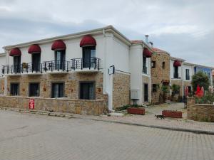een gebouw met rode luifels aan de straatkant bij Hotel Panaya in Gokceada Town