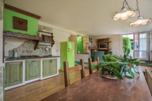 una cucina con armadi verdi e un tavolo con una pianta di BASILIMO di Home Hill a Capannori