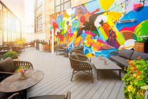 فندق إنديغو ليفربول في ليفربول: لوحة جدارية على جدار مطعم مع طاولات وكراسي