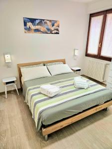 a bedroom with a large bed with two towels on it at Appartamento Alpi Retiche Sondrio in Sondrio +16 photos
