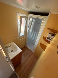 a small bathroom with a sink and a window at n°20 in Biville-sur-Mer