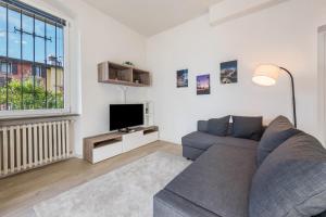 a living room with a couch and a tv at Appartamento La Pergola in Moniga