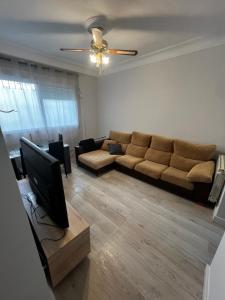 a living room with a couch and a flat screen tv at 3 habitaciones reformado y centrico in Santander