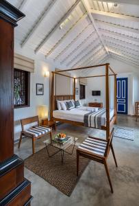 ein Schlafzimmer mit einem Himmelbett und ein Wohnzimmer in der Unterkunft Villa Touch of Dutch in Tangalle