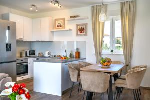 een keuken en eetkamer met een tafel en stoelen bij First Choice Apartment Rogoznica in Rogoznica