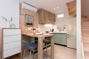 eine Küche mit einem Holztisch und einer Ziegelwand in der Unterkunft La Signora Cofineta by Anita Holiday Homes in Korfu-Stadt + 3 Fotos