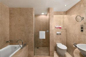 Ramada Plaza by Wyndham Dubai Deira في دبي: حمام مع حوض ومرحاض ومغسلة