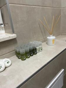 een rij potten met groene vloeistoffen op een aanrecht bij First Choice Apartment Rogoznica in Rogoznica +32 foto's