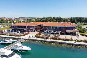 a resort with boats in the water next to a marina at Hotel Nautica - Wellness & SPA, Free parking, Pet friendly in Novigrad Istria