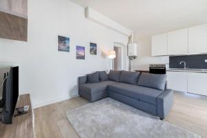 uma sala de estar com um sofá azul e uma cozinha em Appartamento La Pergola em Moniga