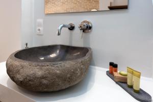 ein Badezimmer mit einem großen Steinwaschbecken auf der Theke in der Unterkunft La Signora Cofineta by Anita Holiday Homes in Korfu-Stadt