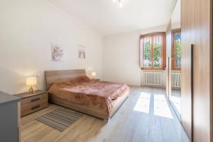 a bedroom with a bed and a desk and windows at Appartamento La Pergola in Moniga