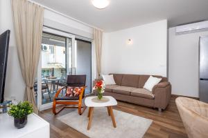 een woonkamer met een bank en een tafel bij First Choice Apartment Rogoznica in Rogoznica